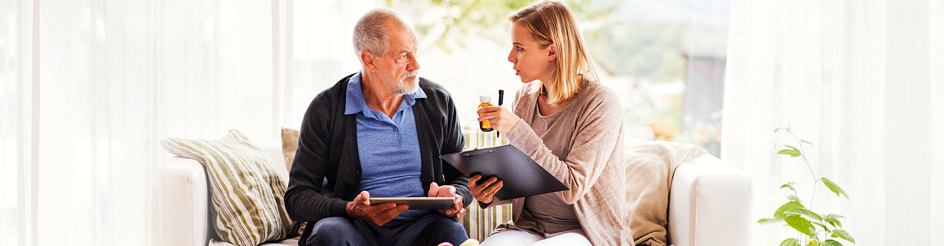 a caregiver giving medicine to a senior man