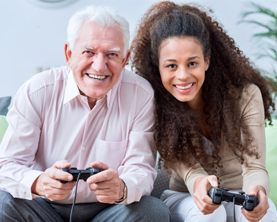 a caregiver and a senior man playing video games